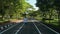 Rear view of a woman wears cap jogging on asphalt road in public park in the morning. Video panning shot.