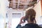 Rear view of a worried woman calling home insurance because the kitchen ceiling has collapsed