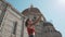 Rear view of young asian girl taking selfie on smartphone or mobile phone in front of dome of cathedral. Woman traveling