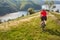 Rear view of the young attractive cyclist riding mountain bike in the summer meadow.