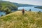 Rear view of the young attractive cyclist riding mountain bike in the summer meadow.