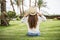 Rear view young beauty Woman in sunhat sitting on the grass on a beach under palms