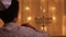 Rear view of a young boy lights a second menorah candle during the Jewish holiday of Hanukkah