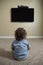 Rear view of a young child watching Television
