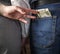 Rear View Of young couple holding hands, second hand wife pulls money from the pocket of her husband`s