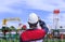 Rear view of young engineer wearing white safety helmet before working on oil tanker ship at shipyard