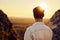 Rear view of young man watching sunset during hiking