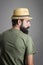 Rear view of young serious bearded man with straw hat looking away