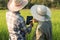 Rear view of young smart farmer couple using digital tablet monitoring and  managing rice field organic farm. Modern technology