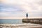 Rear view of young sporty woman standing on a pier by the ocean outside.