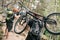 rear view of young trial bikers carrying bikes on backs at forest