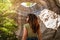 Rear view of a young woman adventurer standing in an underground cave with an opening to the outside, Sunlight through a cave