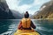 Rear view of young woman kayaking on lake with mountains in background, Female kayaking on a mountain lake, rear view, no face