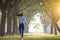 Rear view of young woman running in the forest on  foggy at  morning