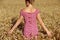 Rear view of young woman standing in wheatfield