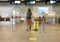 Rear view of Young woman traveler in casual clothes with backpack carrying yellow suitcase at the check-in desk at airport