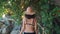 Rear view of young woman walking on wooden bridge in jungle