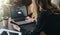 Rear view. Young woman is working on laptop with inscription on screen e-learning and image of square academic cap.