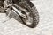 The rear wheel of an off-road motorcycle against the background of a stone pavement. Motorbike parked at empty cobblestone road.