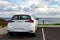 The rear of white modern car in Western Australia parked on a coast of the ocean where people can relax