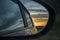 Rear window of auto with view of sundown landscape