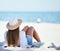 Rearview beautiful young caucasian woman relaxing on the beach. Enjoying a summer vacation or holiday outdoors during