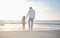 Rearview cute mixed race girl standing hand in hand with her father in the sea at the beach. A young man and his