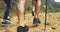 Rearview of hikers walking on a rocky mountain trail with hiking poles. Closeup of a group of active and adventurous