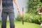 Rearview of a Professional Gardener Holding Lawn Cutting Scissors In The Garden