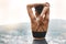 Rearview shot of a young african american female athlete looking at a view while stretching before exercising outside