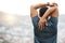 Rearview shot of a young african american male athlete looking at a view while stretching before exercising outside