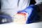 Reasercher picking up colony of a red bacterial culture from agar plate using blue stick wearing gloves in a molecular biology