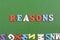 REASONSword on green background composed from colorful abc alphabet block wooden letters, copy space for ad text