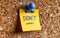 Reassuring note with DONT WORRY! message pinned on a cork bulletin board, providing comfort and positive affirmation in a