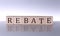 REBATE concept, wooden word block on the grey background