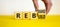 Rebrand and rebuild symbol. Businessman turnsa wooden cubes and changes the word rebrand to rebuild. Beautiful yellow table, white