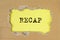 RECAP word inscription on torn craft paper on yellow table