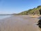 The receding tide leaves wet rippled sand in a small bay