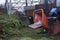Receiver of the wood chipper, trailer and a tractor on a background. Collection point for recycling used Christmas trees