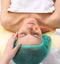 Receiving electric darsonval facial massage procedure.