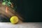 Recently collected lemon on the wooden table leaving against an old wall and a beam of a sunlight. Front view. Horizontal