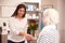 Receptionist Greeting Female Patient At Hearing Clinic