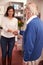 Receptionist Greeting Senior Male Patient At Hearing Clinic