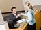 Receptionist greeting woman at front desk