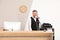 Receptionist talking on telephone at desk in hotel