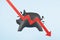 Recession concept with red arrow hitting black piggy bank at blue background