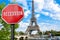 Recession stop sign with view of Eiffel tower in Paris, France. Financial crash in world economy because of coronavirus pandemic.