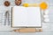 Recipe cook blank book on wooden background, spoon, rolling pin, checkered tablecloth. Top view
