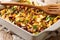 Recipe for a delicious frito pie with ground beef, cheese, corn, beans and chips close-up in a baking dish. horizontal