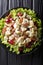Recipe for delicious Sonoma salad with chicken breast, celery, pecans and grapes covered with sauce close-up. Vertical top view